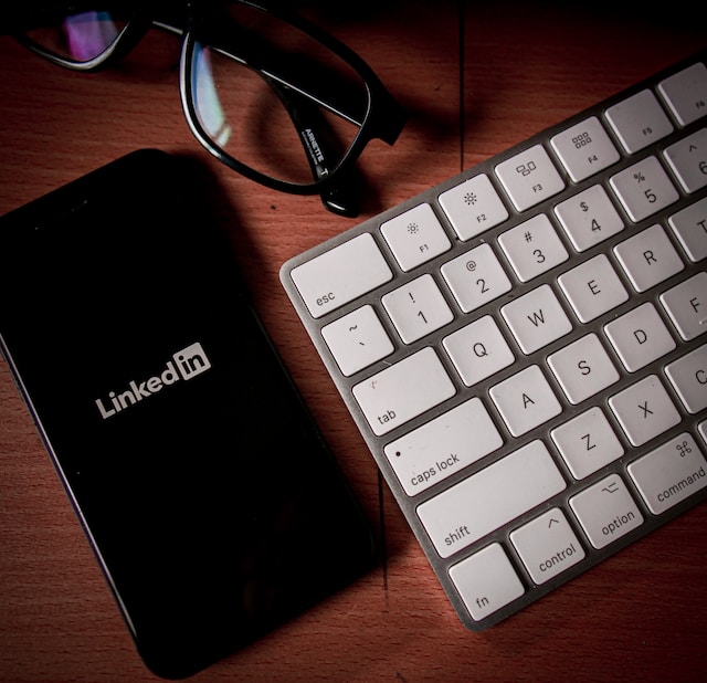 LinkedIn Social Media Marketing Digital Strategy. Photo of iPhone with LinkedIn logo on screen next to Apple keyboard.