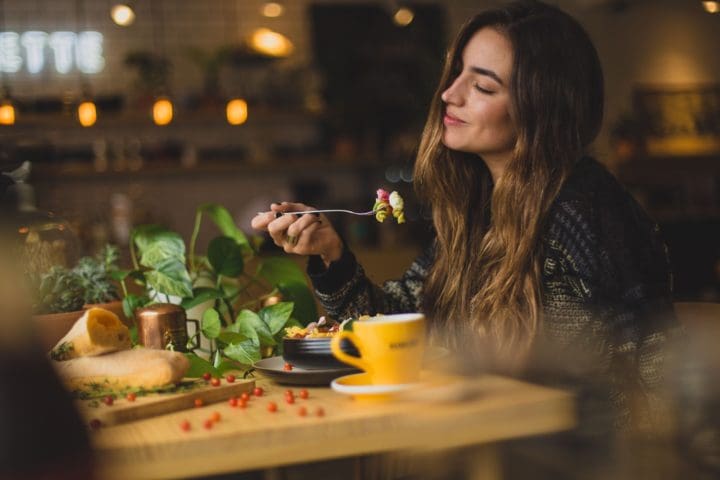 woman holding fork in front table mindful eating